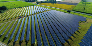 0424 birdseye-view-of-fields-of-solar-panels-sun-shining-down